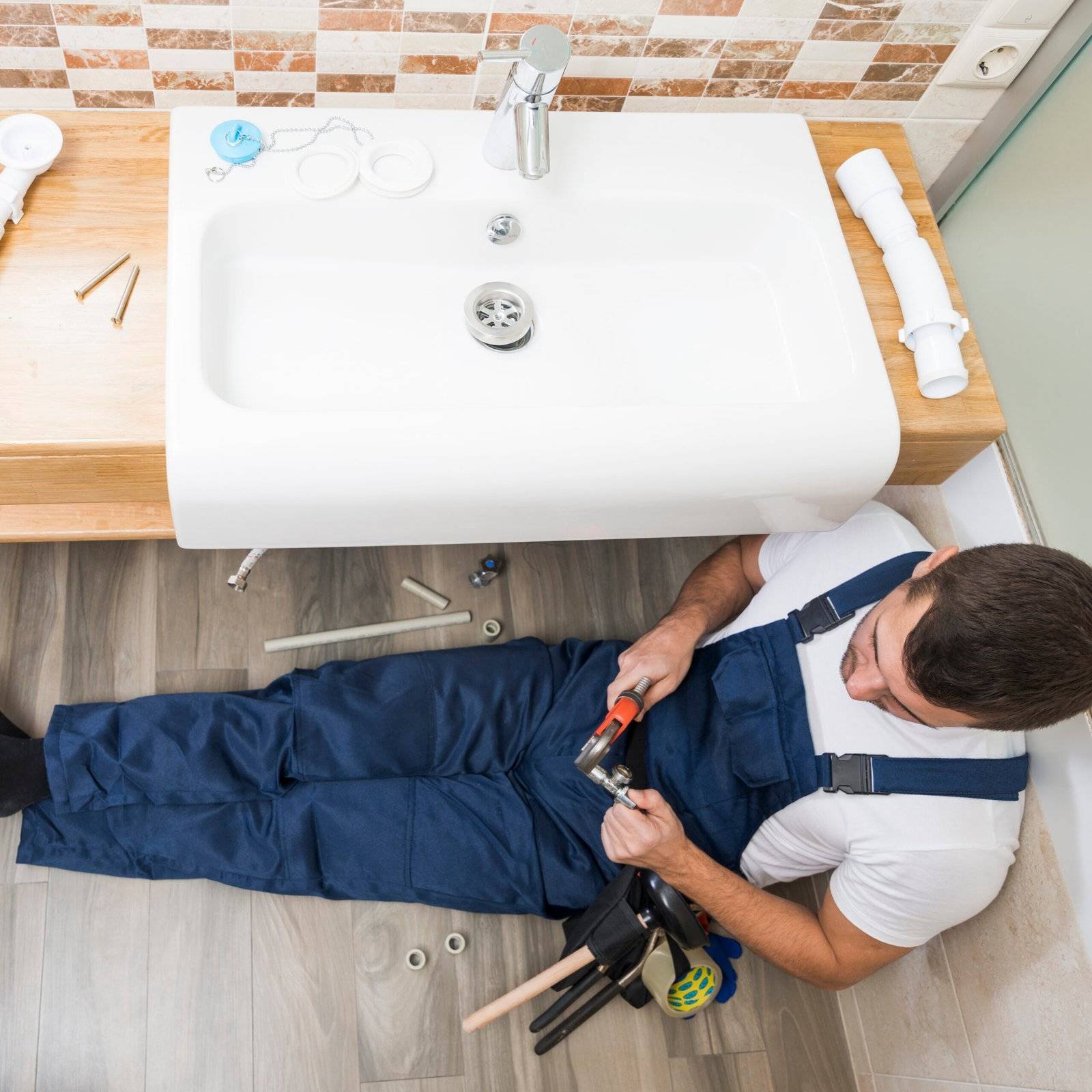 sanitary technician working with sink scaled